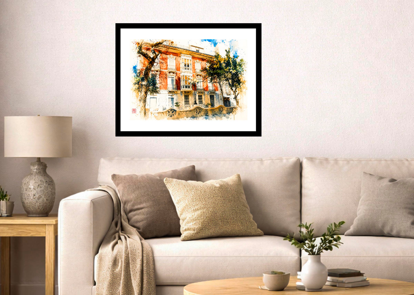 Lámina decorativa Plaza del Doctor Balmis enmarcada en negro sobre sofá blanco con cojines beige, lámpara de cerámica y jarrón con plantas, salón mediterráneo luminoso IMAJIN-ARTE