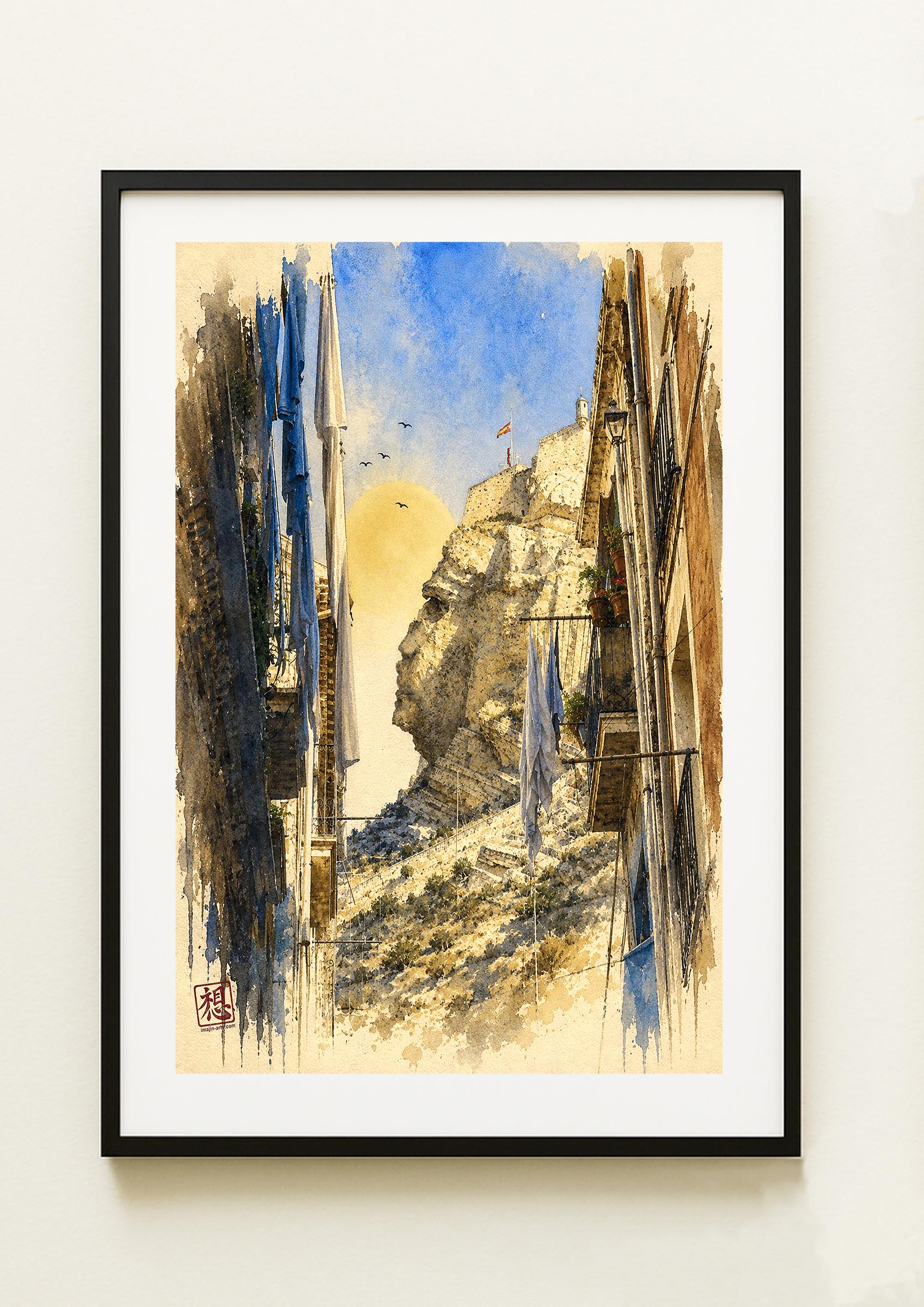Lámina decorativa Cara del Moro II enmarcada, acuarela vertical de calle estrecha del barrio Santa Cruz de Alicante con ropa tendida entre balcones y peñón del Castillo de Santa Bárbara al fondo, cuadro marco negro paspartú blanco IMAJIN-ARTE