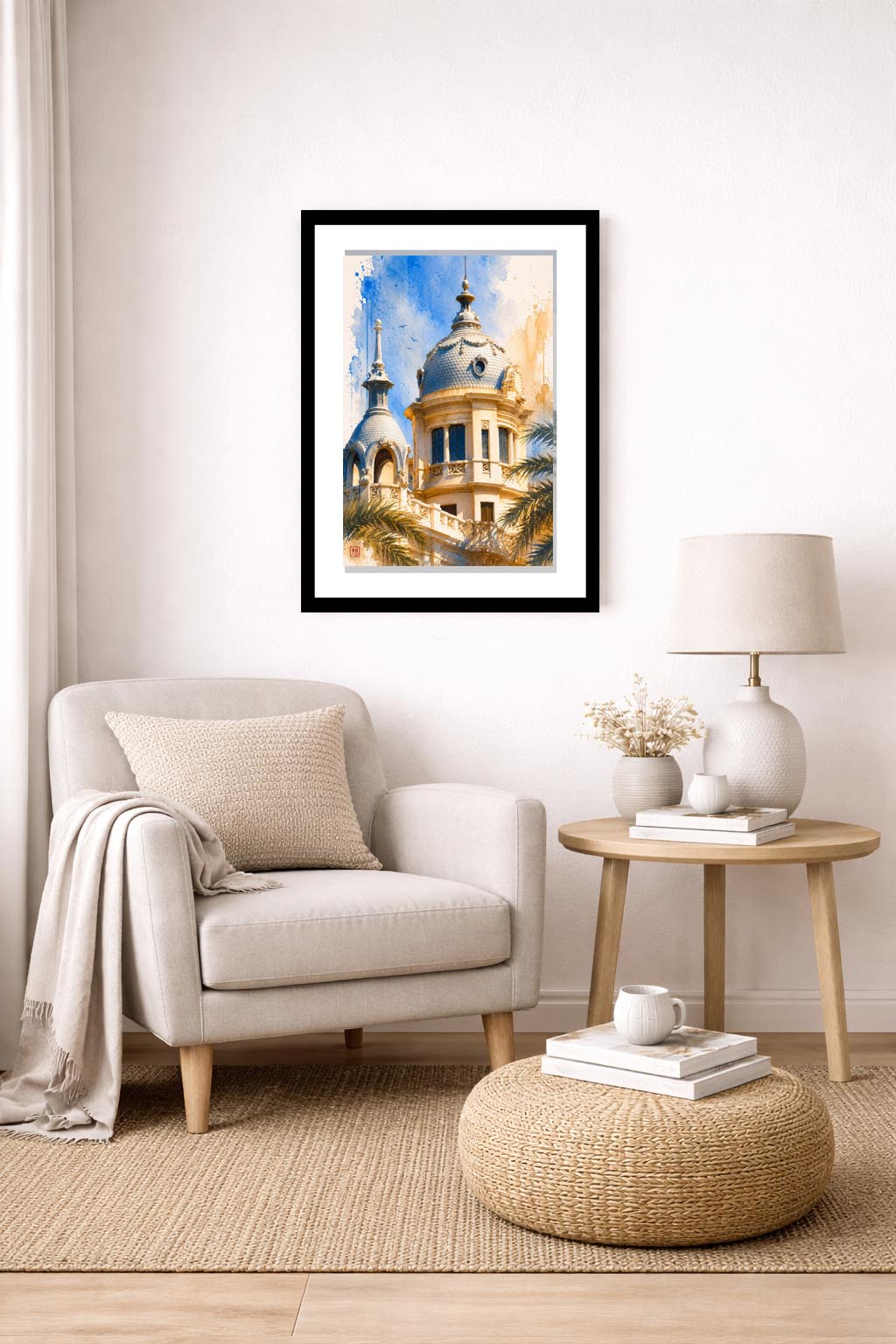 Lámina decorativa Cúpula Casa Carbonell enmarcada en negro sobre sillón beige con manta, mesa auxiliar de madera con flores secas y lámpara, rincón de lectura luminoso y acogedor. IMAJIN-ARTE