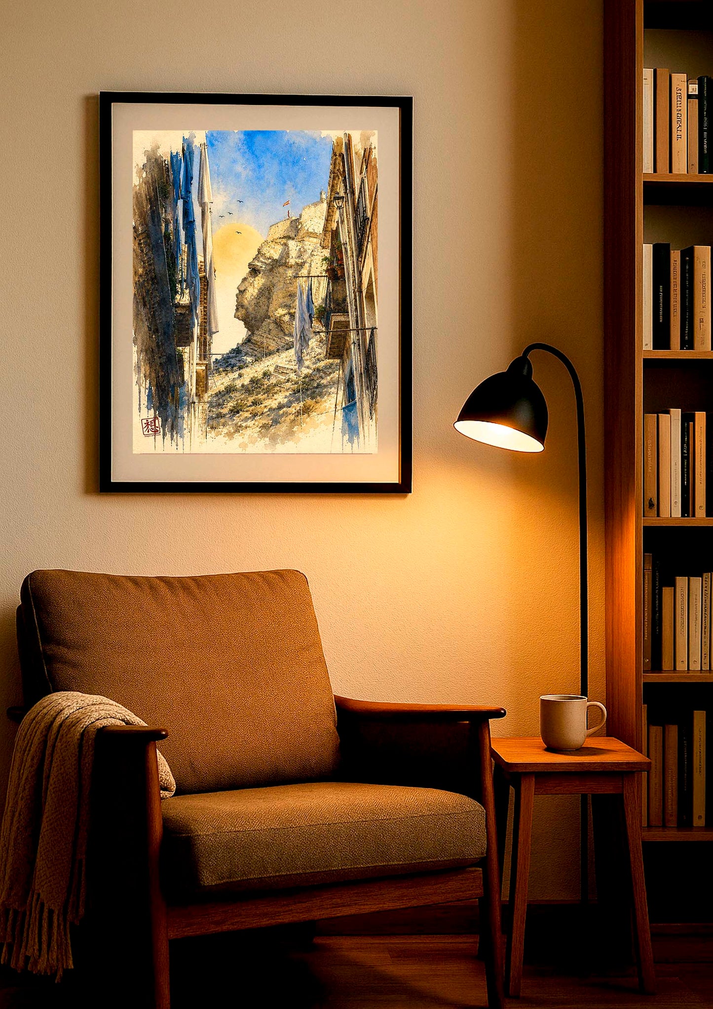 Cuadro enmarcado Cara del Moro II en rincón de lectura con sillón vintage mostaza, lámpara de pie negra encendida con luz cálida y librería de madera al fondo, acuarela vertical de calle del barrio Santa Cruz de Alicante IMAJIN-ARTE